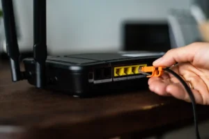 man-plugging-ethernet-cable-wireless-router